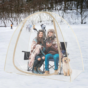 2 people and a dog, cozy and warm in the snowy terrain inside the TopGold 2-4 Person weatherproof pod